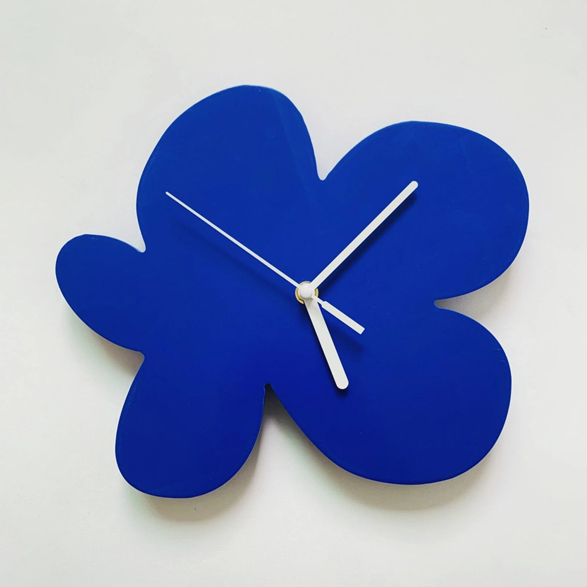 horloge murale design forme fleur bleu klein aiguilles blanches décoration salon moderne