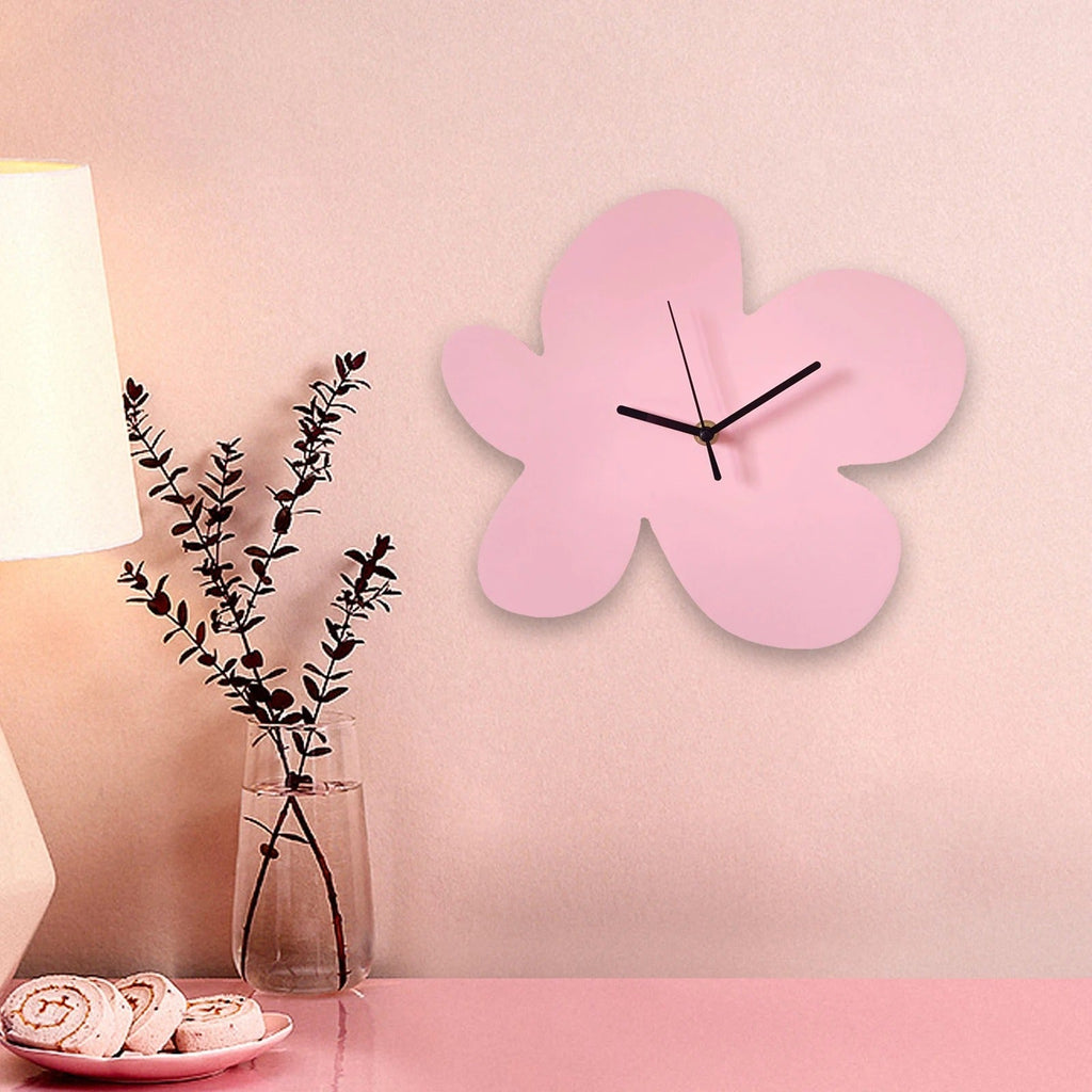 Horloge murale fleur rose sans chiffres aiguilles noires mise en situation chambre